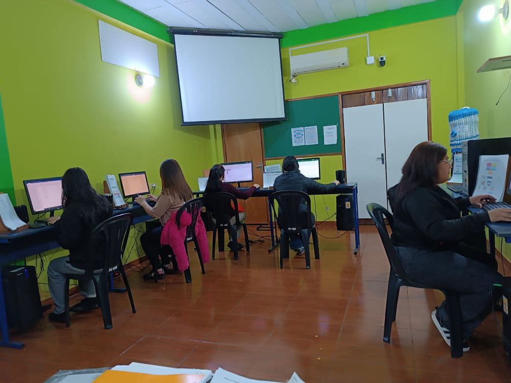 Alumnos trabajando cada uno en su computadora durante una clase.
