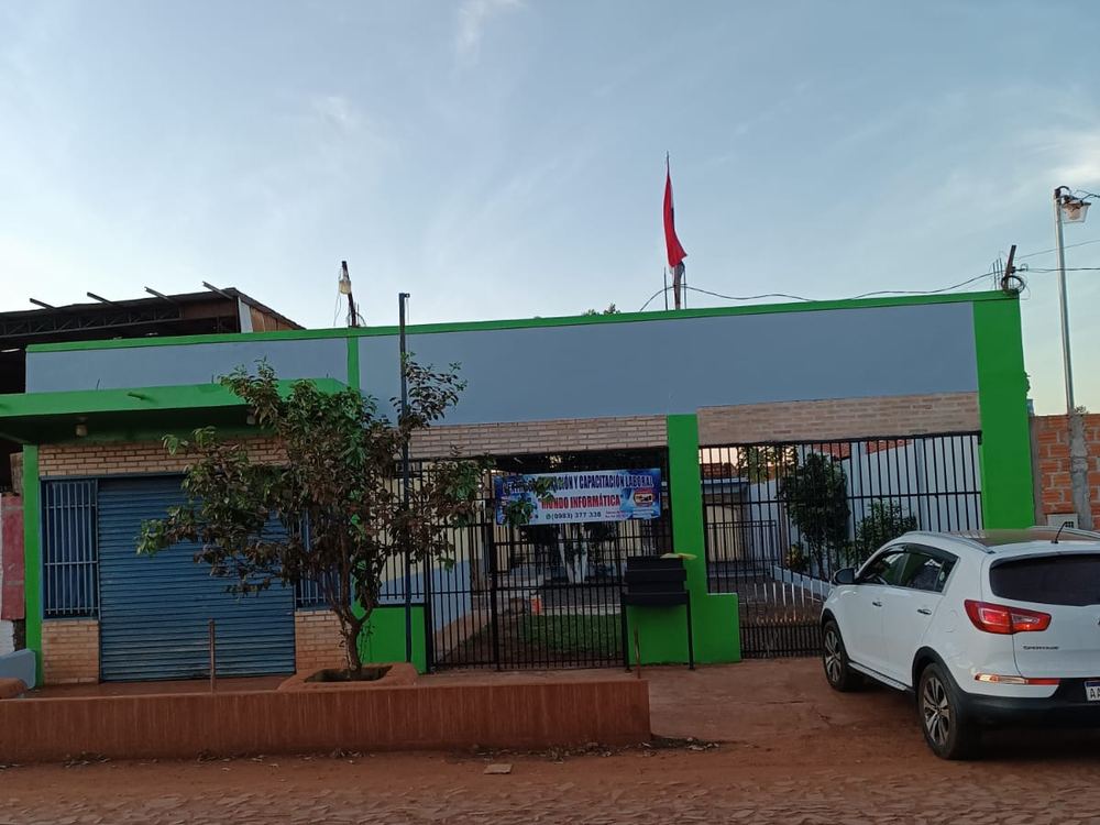 La fachada del instituto vista desde la calle empedrada, con la bandera paraguaya.